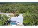Aerial view of home showcasing pool and lush wooded surroundings at 16249 Ashland Ave, Port Charlotte, FL 33954