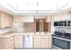 The kitchen features stainless steel appliances, light wood cabinets, and tile flooring at 16249 Ashland Ave, Port Charlotte, FL 33954