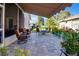 Backyard featuring a stone patio, outdoor seating, and mature landscaping at 1701 Lastingham Ln, Port Charlotte, FL 33980