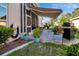 Outdoor patio with BBQ grill, lush landscaping, and retractable awning at 1701 Lastingham Ln, Port Charlotte, FL 33980