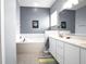 Bathroom features a large soaking tub, white vanity with marble countertop, and neutral tile at 1701 Lastingham Ln, Port Charlotte, FL 33980
