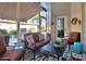 Inviting patio with comfortable seating, floral rug, and a retractable awning for shade at 1701 Lastingham Ln, Port Charlotte, FL 33980