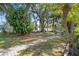 Charming backyard with lush greenery, a paved pathway, and mature trees offering shade and privacy at 17380 Shirley Ave, Port Charlotte, FL 33948