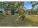 Expansive backyard featuring mature trees, a birdbath, and a screened-in pool area, perfect for outdoor enjoyment at 17380 Shirley Ave, Port Charlotte, FL 33948
