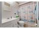 Bright bathroom featuring a white vanity and beach-themed shower curtain at 17380 Shirley Ave, Port Charlotte, FL 33948