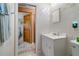 Bathroom with white tiled walls and a doorway leading to a bedroom at 17380 Shirley Ave, Port Charlotte, FL 33948