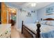 Bedroom featuring blue walls, wooden furniture, and a glimpse into a sunlit dining area at 17380 Shirley Ave, Port Charlotte, FL 33948