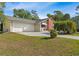 Charming home featuring a two-car garage, well-manicured lawn, and mature trees providing ample shade at 17380 Shirley Ave, Port Charlotte, FL 33948