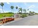 Community entrance with signage, mature trees and landscaping, and an American flag at 175 Kings Hwy # 736, Punta Gorda, FL 33983