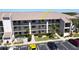 Three-story condo building showcasing parking and tropical landscaping at 175 Kings Hwy # 736, Punta Gorda, FL 33983