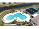 Aerial view of a large, uniquely shaped pool with palm trees and lounging chairs at 175 Kings Hwy # 736, Punta Gorda, FL 33983