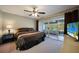 Main bedroom featuring tan carpet, a queen-sized bed, sliding glass doors and a ceiling fan at 179 Boundary Blvd # 4, Rotonda West, FL 33947