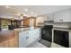 Kitchen featuring white cabinets, a breakfast bar, black appliances, and easy access to the living room at 179 Boundary Blvd # 4, Rotonda West, FL 33947