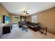 Comfortable living room with tan carpet, ceiling fan, a brown leather couch, and sliding glass doors at 179 Boundary Blvd # 4, Rotonda West, FL 33947