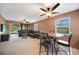 Spacious living room with tan carpet, ceiling fan, a brown leather couch, and sliding glass doors at 179 Boundary Blvd # 4, Rotonda West, FL 33947