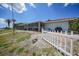 Exterior view of home with long, screened in patio and white picket fence at 1791 Belle Ct, Punta Gorda, FL 33950