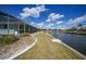 Home's backyard featuring waterfront access with a lawn and patio at 1791 Belle Ct, Punta Gorda, FL 33950