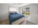 Bedroom features blue bedding, tile floors, ceiling fan, and large windows with views of tropical landscaping at 1791 Belle Ct, Punta Gorda, FL 33950