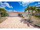 Charming single-story home with a tile roof, palm trees, and a patterned driveway, offering curb appeal at 1791 Belle Ct, Punta Gorda, FL 33950