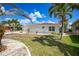 Inviting single-story home with a red tile roof, well-maintained lawn, and mature palm trees in a peaceful setting at 1791 Belle Ct, Punta Gorda, FL 33950