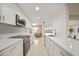 Bright kitchen features white cabinets, modern appliances, and long countertops overlooking living area at 1791 Belle Ct, Punta Gorda, FL 33950