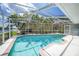 Sparkling pool with screened enclosure and lush landscaping and palm trees at 1791 Belle Ct, Punta Gorda, FL 33950