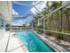 Backyard pool in a screened enclosure with mature landscaping and lush greenery at 1791 Belle Ct, Punta Gorda, FL 33950