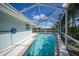 Backyard pool inside of a screen cage with brick trim and blue skimmer at 1791 Belle Ct, Punta Gorda, FL 33950