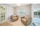 Bright sitting room features tiled floors, two chairs, and views of canal at 1791 Belle Ct, Punta Gorda, FL 33950