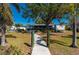 Well-maintained backyard featuring mature trees, lush landscaping, and a charming walkway leading to the house at 18417 Ohara Dr, Port Charlotte, FL 33948