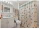 Bright bathroom with light fixtures and ocean-themed shower curtain and neutral vanity at 18417 Ohara Dr, Port Charlotte, FL 33948