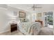 Cozy bedroom featuring a ceiling fan and an ensuite bathroom and access to the lanai at 18417 Ohara Dr, Port Charlotte, FL 33948