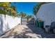 Wide paver driveway leading to gate, yard features privacy fence with trash receptacles at 18417 Ohara Dr, Port Charlotte, FL 33948