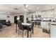 Open concept kitchen with stainless steel appliances, white cabinets, and tile flooring, seamlessly connected to the living area at 18417 Ohara Dr, Port Charlotte, FL 33948
