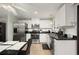 Modern kitchen featuring stainless steel appliances, white cabinetry, black countertop, and a bright window with plantation shutters at 18417 Ohara Dr, Port Charlotte, FL 33948