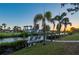 A serene waterfront view showcasing a wooden dock and tropical landscaping at 18417 Ohara Dr, Port Charlotte, FL 33948