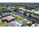 Aerial view of a waterfront home with a pool and dock on a picturesque canal at 18462 Alphonse Cir, Port Charlotte, FL 33948