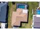 Aerial view of the roof and backyard, featuring a pool, landscaping, and a well-maintained lawn at 18462 Alphonse Cir, Port Charlotte, FL 33948