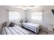 Bright bedroom with two twin beds, ceiling fan, and large windows at 18462 Alphonse Cir, Port Charlotte, FL 33948