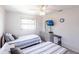 Well-lit bedroom featuring two twin beds, a ceiling fan, and dresser storage at 18462 Alphonse Cir, Port Charlotte, FL 33948