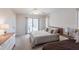 Bright bedroom featuring two beds, a slider to the screened porch, and side tables at 18462 Alphonse Cir, Port Charlotte, FL 33948