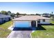 Charming single-story home with a well-manicured lawn, a paved driveway, and an attached two-car garage at 18462 Alphonse Cir, Port Charlotte, FL 33948