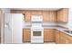 Functional kitchen featuring white appliances, light wood cabinets, and neutral countertops for a classic look at 18462 Alphonse Cir, Port Charlotte, FL 33948