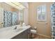 Bathroom with a large mirror, white countertops, tile flooring, toilet, and a floral shower curtain at 2024 Calusa Lakes Blvd, Nokomis, FL 34275