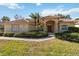 Charming home with a tile roof and manicured front yard, showcasing lush landscaping and a welcoming entrance at 2024 Calusa Lakes Blvd, Nokomis, FL 34275