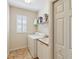 Efficient laundry room with a washer, dryer, utility sink, storage cabinets, and a window for natural light at 2024 Calusa Lakes Blvd, Nokomis, FL 34275
