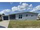 Single-story home featuring a fenced front patio, attached one-car garage, and a grassy front yard at 22262 Midway Blvd, Port Charlotte, FL 33952