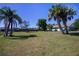Rear exterior view of home and expansive backyard with mature trees and lush lawn at 23051 Elmira Blvd, Punta Gorda, FL 33980