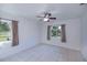 Bedroom with tan-colored walls, neutral tile floors, a ceiling fan and two windows with curtains at 23051 Elmira Blvd, Punta Gorda, FL 33980