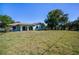 Back exterior with large yard and covered patio with multiple sliders to the inside at 23051 Elmira Blvd, Punta Gorda, FL 33980